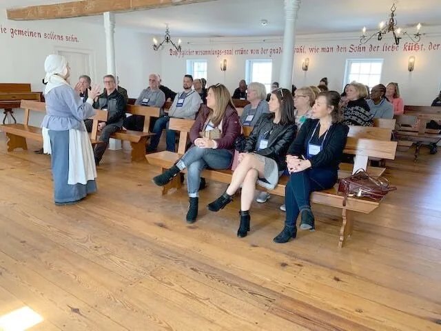 Guide in costume speaking to visiting group in the Saal of the Moravian Museum.