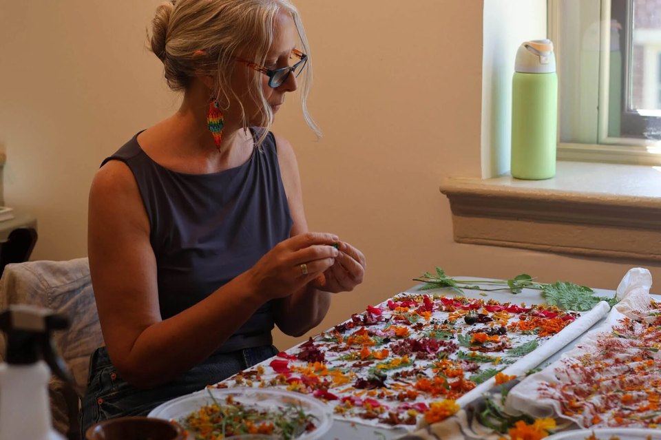 A woman at a craft weekend making natural dye out of bright colored flowers during a heritage craft weekend at Historic Bethlehem Museums & Sites.